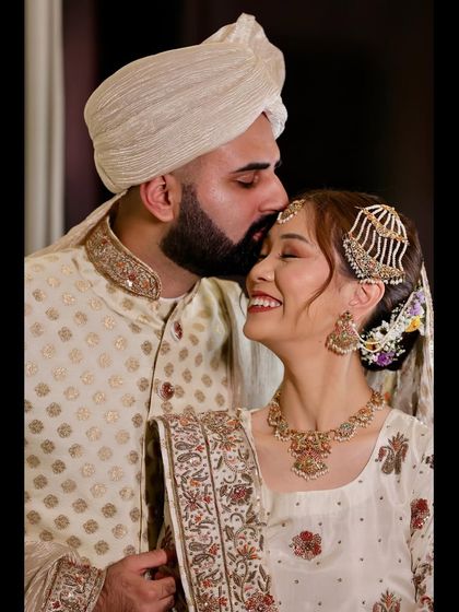 A tender moment between a groom and his bride, kissing her forehead. This photo beautifully captures the love and respect in their relationship on their wedding day.