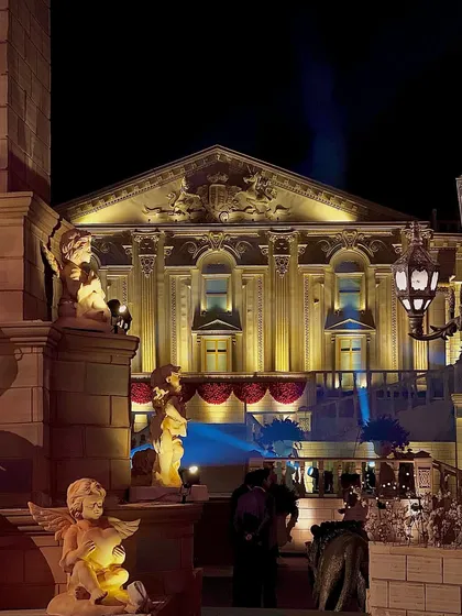 Cherubic statues and ornate street lamps frame the view of the Buckingham Palace set. These details were crucial in building an authentic and romanticized vision of London for a royal-themed affair.