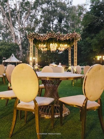 Gold and cream chairs for the guest tables, adding a touch of regal elegance to the outdoor reception.