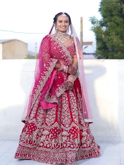 A full-length view of this stunning bride. Her makeup was crafted to complement the intricate details of her pink lehenga, ensuring she looked flawless from head to toe.