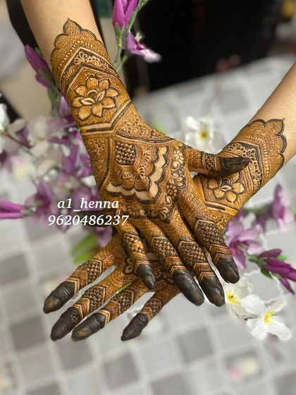 A striking design featuring a large floral motif in the center, with detailed patterns on the fingers and a cuff at the wrist.