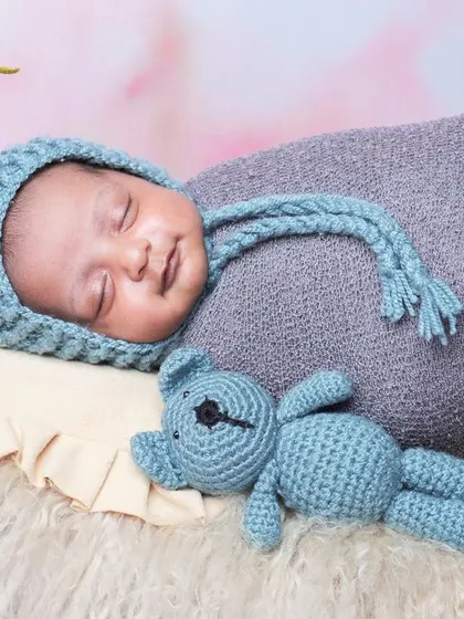 Capturing a precious sleepy smile on this newborn, dressed in a mouse-eared hat and resting in a comfortable prop basket.