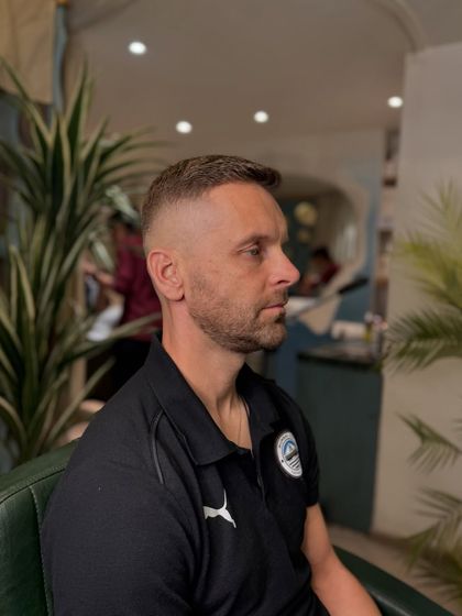 The power of a haircut, side view. This is a classic short haircut with a high and tight fade, a timeless look.