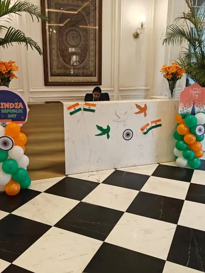 The reception desk is decorated with tricolor balloon pillars and custom "India Republic Day" signs. The checkered floor provides a striking contrast to the festive decorations.