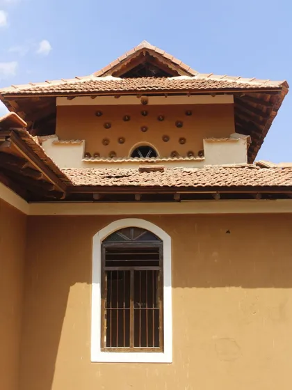The exterior view of the ventilation detail, showing how simple, locally sourced materials like clay pots can be used to create functional and beautiful architectural features that are unique to mud construction.