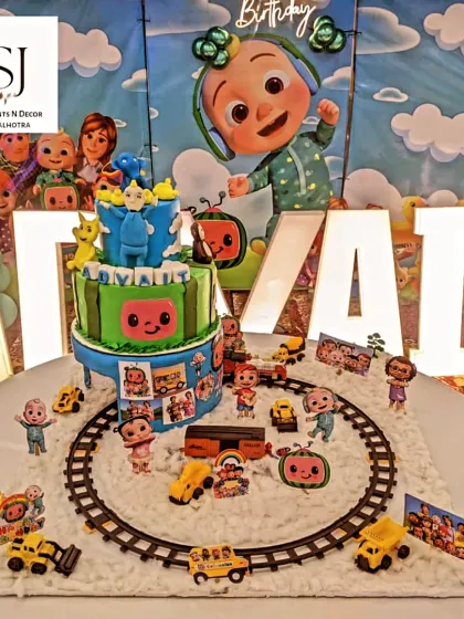 A close-up of the incredible Cocomelon-themed cake, complete with a toy train track and all the main characters.