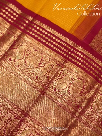 A stunning red and yellow contrast Kanjivaram with rich zari checks and a traditional border, a perfect pick for Varamahalakshmi.