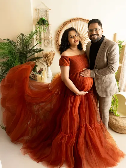 A full-length couple portrait showcasing the magnificent trail of the maternity gown. I ensure both partners look connected and poised.