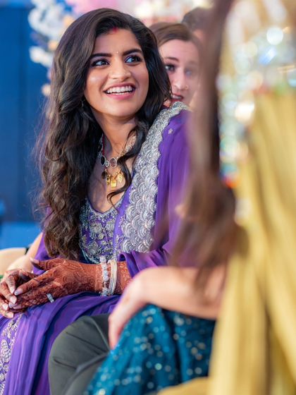 A candid shot of the bride enjoying her reception. Her happy expression says it all. The custom purple outfit was not only beautiful but also comfortable enough for her to relax and enjoy her evening.