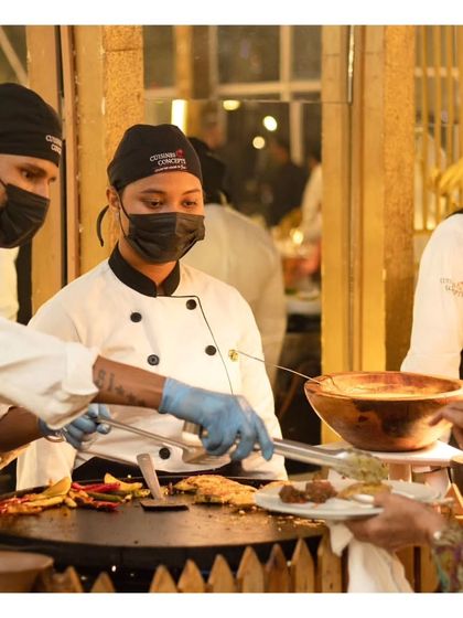 Our team of chefs working in unison at a live tawa station. This image showcases the teamwork and professionalism of our culinary staff, ensuring efficient and high quality service.