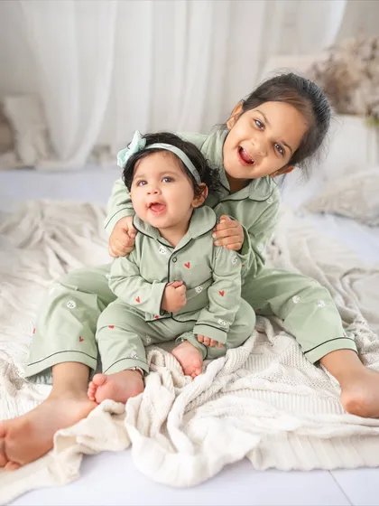 A fun pajama party for two sisters during a milestone session. I love capturing the pure joy and playful bond between siblings in my studio with fun themes and coordinated outfits.