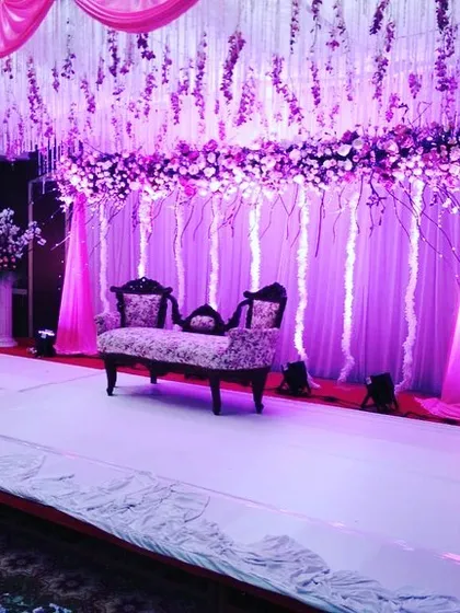 For a modern and dreamy sangeet or reception, I designed this stage with cascading purple wisteria. The dramatic purple uplighting and minimalist settee create a sophisticated and magical atmosphere.