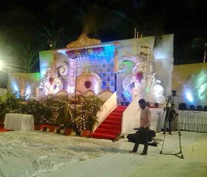 A wider angle of the reception stage setup, showing the red carpet walkway and surrounding plant decor. This view captures the complete look before the guests arrive, highlighting our team's preparation.