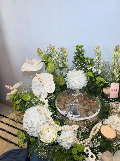 A top-down view of the silver-themed hamper, showing the intricate details of the pearl strings and the arrangement of white florals.