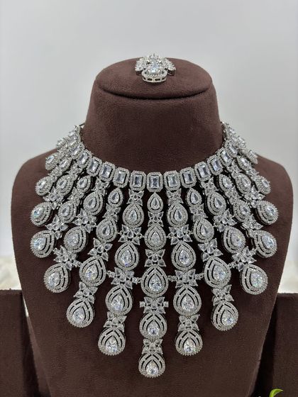 A magnificent, full-coverage AD necklace set designed for grand events. The intricate web of American Diamonds creates a dazzling effect, perfect for bridal and reception wear.