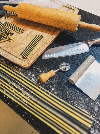 The tools of the trade for pasta making. A rolling pin, pasta wheel, and fresh dough are all that's needed to begin the process of creating something special.