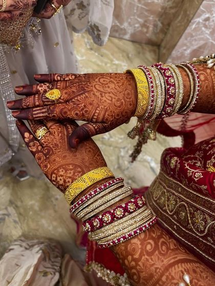 The henna stain looks vibrant and rich, complementing the bride's traditional jewelry.
