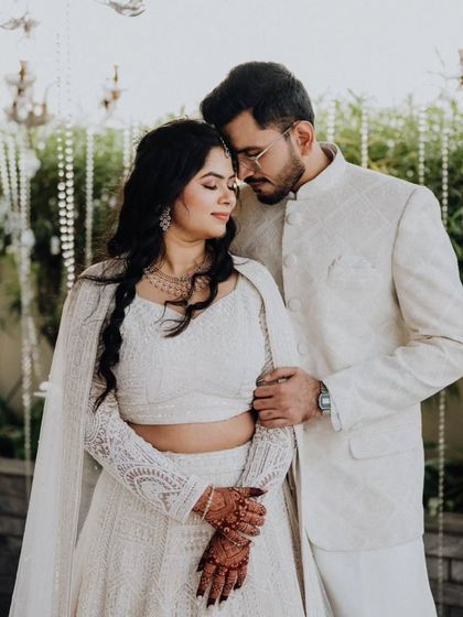 A beautiful portrait of the couple in their elegant white outfits, a moment of calm connection.