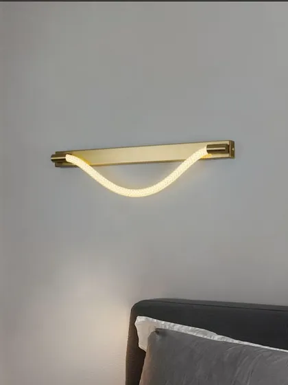 A minimalist wall sconce with a flexible LED tube on a brass bar. This versatile design can be used as a bedside lamp or hallway light.