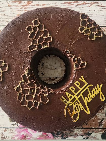 My bestseller chocolate cake, but in a donut shape and soaked in Kahlua. This boozy version is covered in dark chocolate ganache and decorated with gold lattice work for an elegant finish.