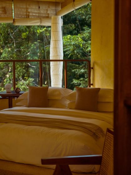 A peek into one of our suites, where the bed is oriented towards the balcony and the forest view, ensuring a peaceful start to your day.