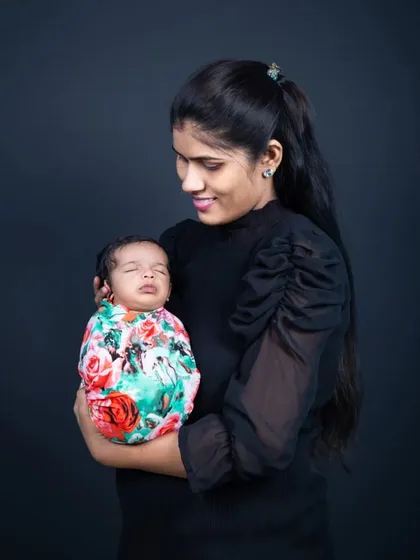 A mother's love, holding her peacefully sleeping newborn for a classic portrait.