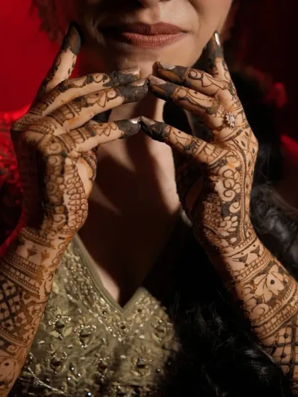 A dramatic shot of a bride's hands with a deep, dark henna stain. The color is intense and beautiful.