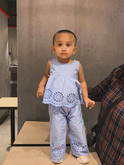 My daughter sitting on the floor in a cute blue outfit from Firstcry. This was part of the "Mom of All Sales" promotion.