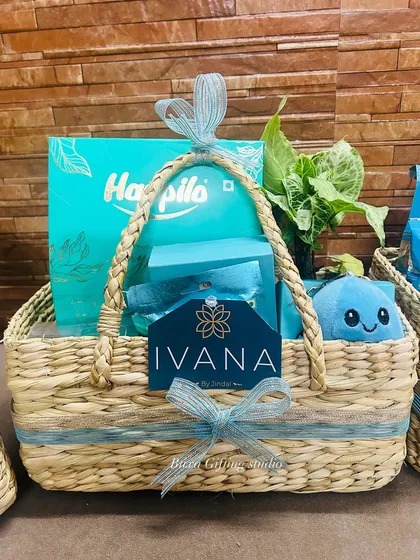 A close-up of the Ivana by Jindals hamper, highlighting the branded card, premium dry fruit box, and other turquoise-themed items.