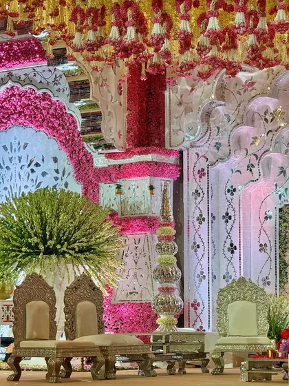 A close-up of the royal seating and intricate floral pillars of the mandap. Every element is designed to contribute to a cohesive vision of elegance and tradition.