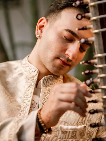 Another close-up, highlighting the detailed embroidery on the collar of the kurta, which mirrors the intricacy of the music.