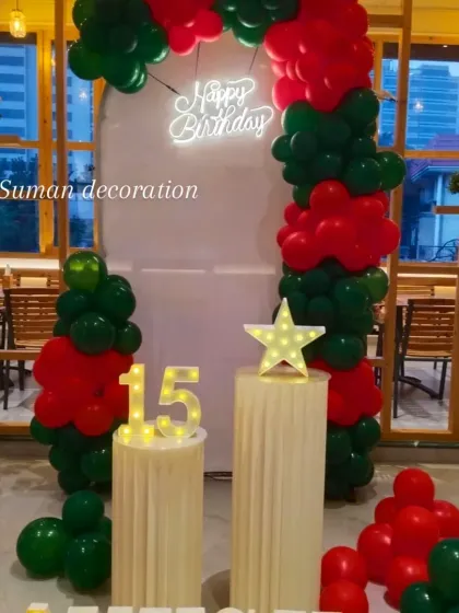 A wider view of the red and green birthday setup, showing how it looks within the venue space.