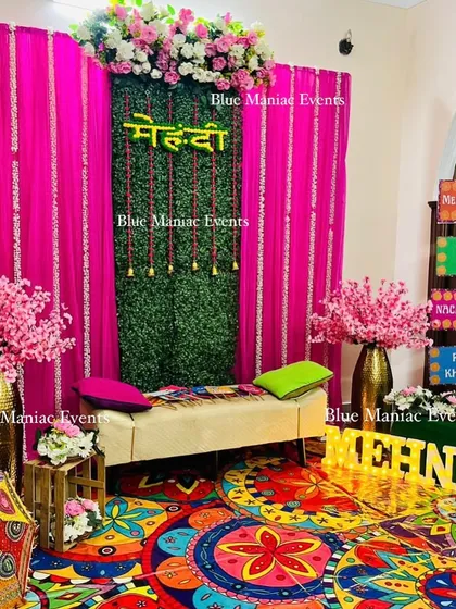 A full view of the funky Mehendi setup, showing how the colorful printed carpet ties all the vibrant elements together, from the pink backdrop to the quirky props.