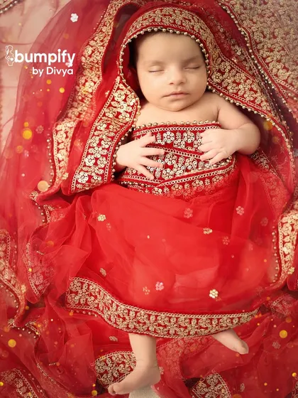 Wrapped in a stunning miniature red and gold lehenga, this newborn looks like a tiny sleeping princess. I love creating these traditional looks that connect your baby's first portraits to your family's heritage.