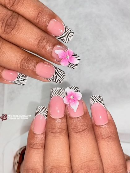 Elegance is in the details. This set combines a classic French tip with a bold zebra print and a delicate 3D pink flower for a unique look.