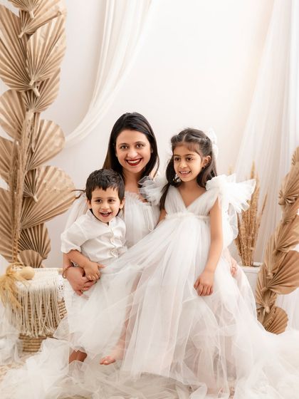 Another beautiful moment from the all-white session, this time with the mother holding both her children. The composition emphasizes their unity and the mother's loving embrace.