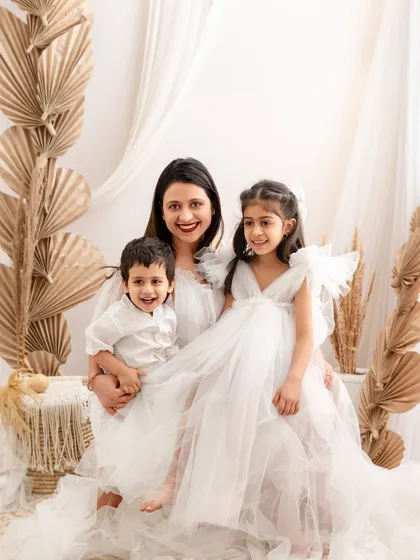 A lovely family photo of a mother and her two children, smiling happily together in our boho-chic studio setup.