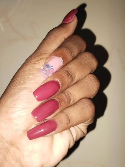A simple yet bold set of long, square-shaped extensions. Most nails are a solid deep mauve, with a single accent nail featuring a clear tip with embedded glitter for a "glass nail" effect.
