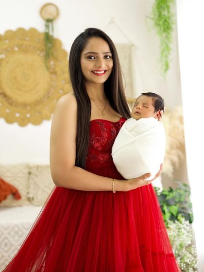 A smiling mother holds her baby, a perfect portrait capturing the happiness of this new chapter.