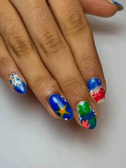 For the ocean lover. We created a vibrant underwater world with turtles, crabs, and starfish. This detailed nail art is perfect for a beach vacation or to show your love for marine life.