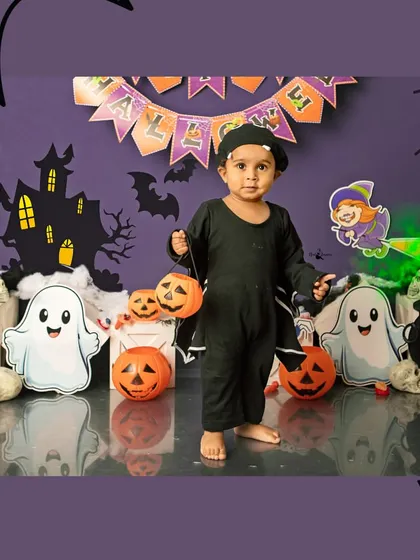 This little one is all set for a night of trick-or-treating with his pumpkin pails. The spooky decor adds to the fun of the Halloween mini session.