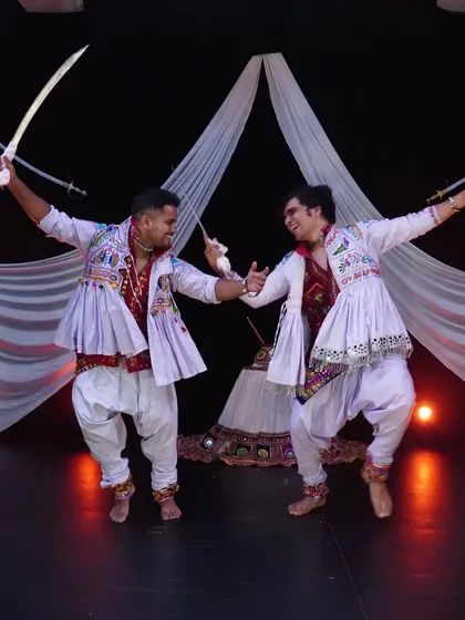 The energy between two performers is key in a duet like this. Here, we are captured mid-movement during a dynamic sword dance sequence, showcasing the precision and power involved.