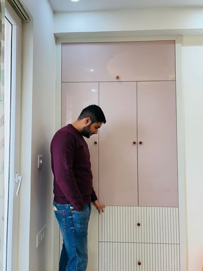 A custom wardrobe in a soft pink laminate with unique grooved details on the drawers, part of a project at ATS Nobility.