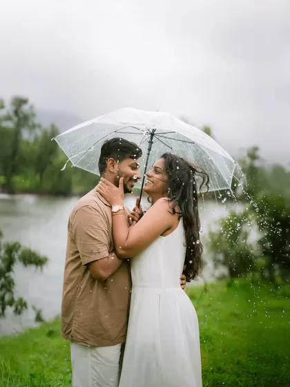Some love stories feel like a movie. Sheltered from the monsoon rain, this quiet moment between a couple becomes a timeless portrait of their connection, proving that even a simple umbrella can frame a world of romance.