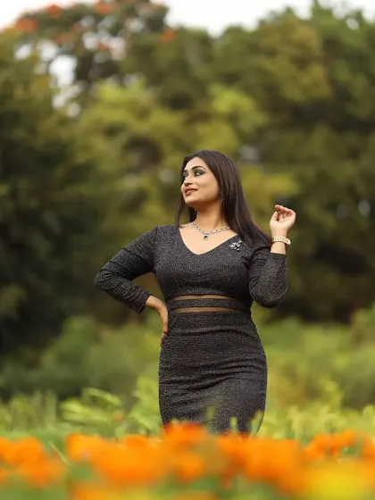 A full-length shot capturing the entire modern glam look, from the smokey eye makeup to the chic black dress.
