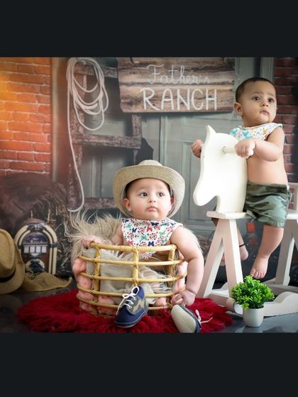 These twin cowboys are partners in crime. The setup allows for both individual and group shots, capturing the unique bond between siblings in a fun, themed environment.