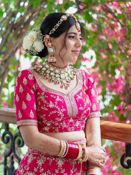 A beautiful bridal portrait taken outdoors, with a vibrant pink bougainvillea creating a stunning natural backdrop.
