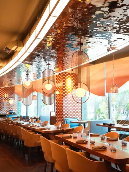 Welcome to our Mumbai dining room, a space designed for connection and celebration. The shimmering ceiling and warm lighting create an elegant yet comfortable setting, perfect for everything from a corporate dinner to a large family gathering.