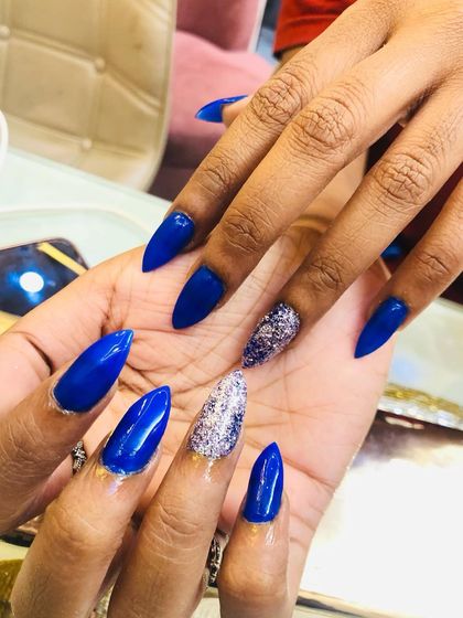 A close-up of the vibrant blue and sparkling silver nails.