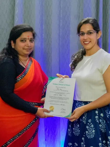 I am proud to present a student with her graded music exam certificate. I provide dedicated coaching for international certifications from Trinity, ABRSM, and other prestigious music boards.